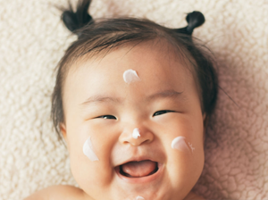 Bebé con crema en el rostro