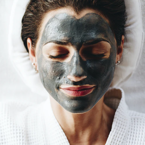 Mujer con mascarilla de carbón