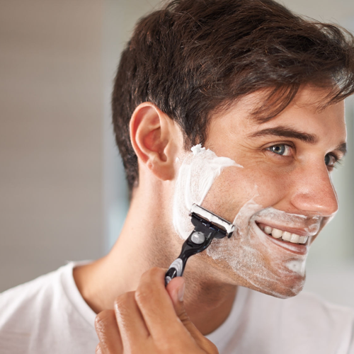 Hombre afeitándose usando espuma de afeitar