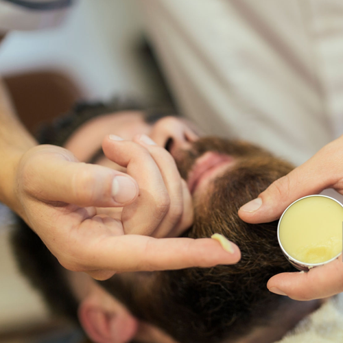 Hombre aplicándose emoliente para barba